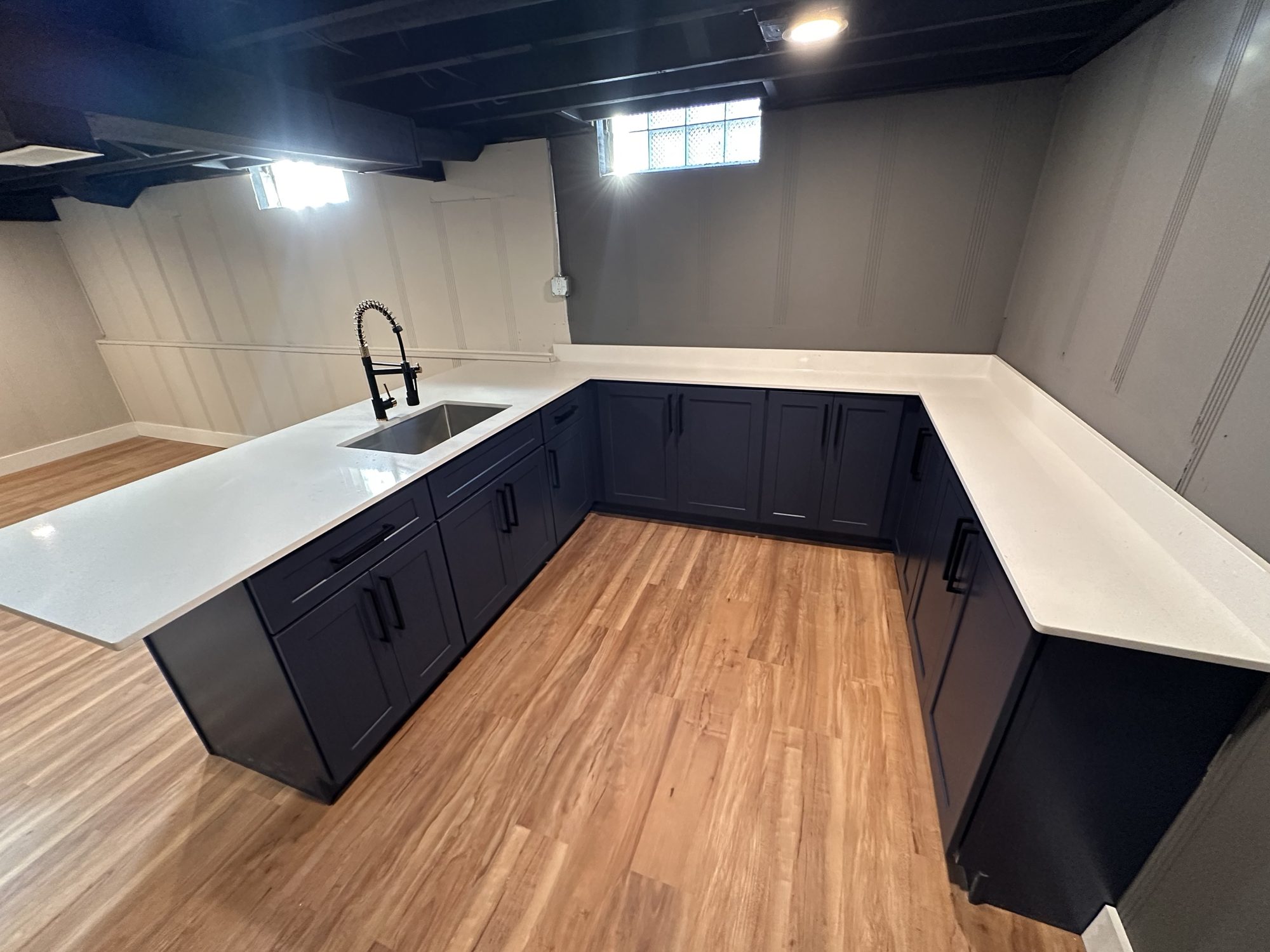 Navy shaker basement bar with white quartz counters