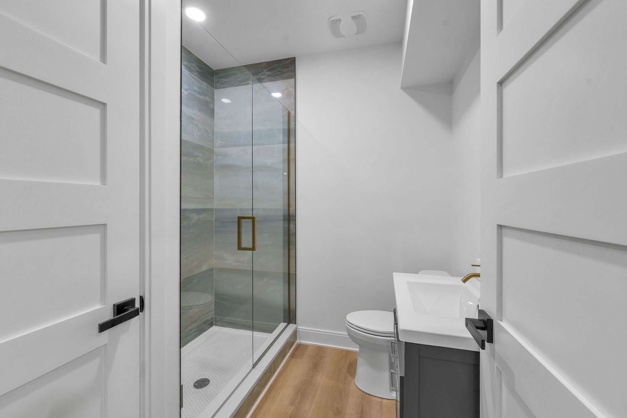 Guest bath with onyx-look tile shower and gray vanity