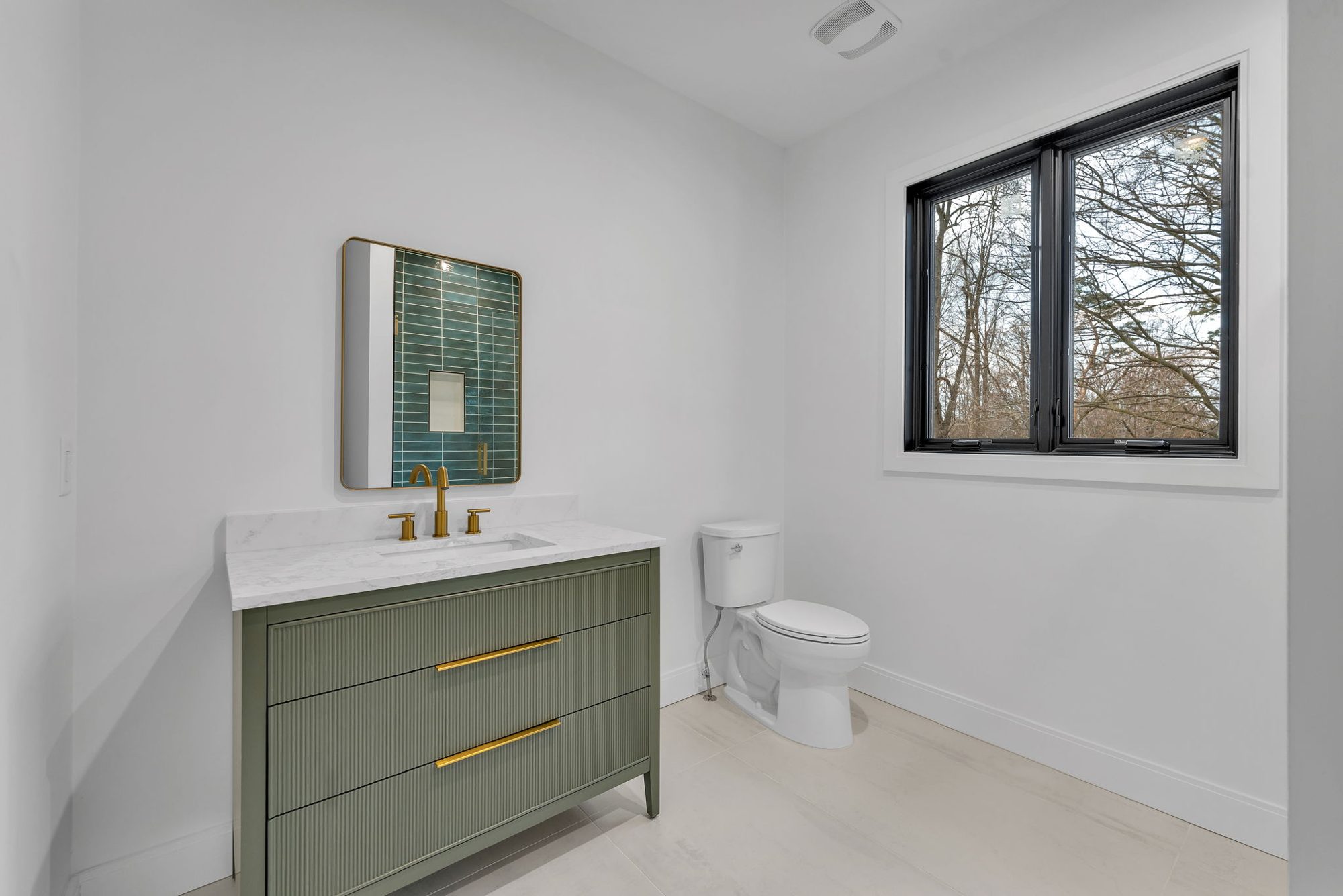 Sage green fluted vanity with marble top and brass faucet