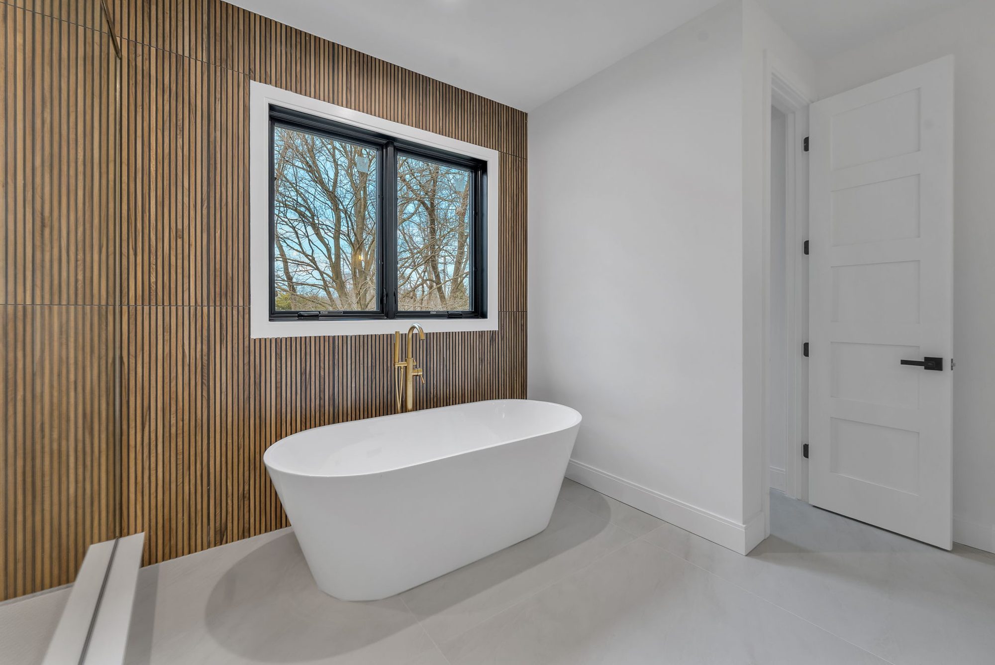 Freestanding tub against wood slat wall