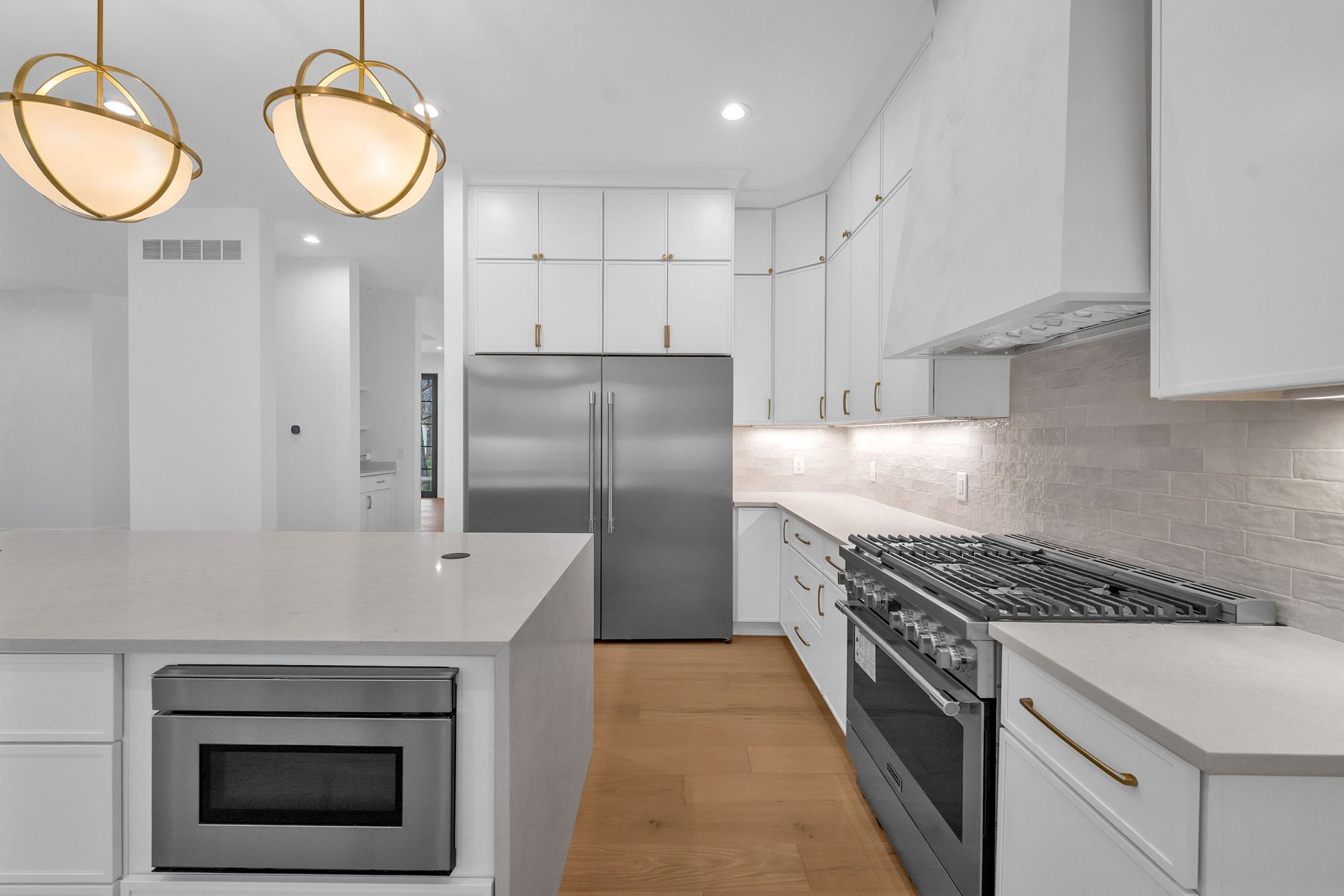 Pro range and paneled column fridge with brass pulls