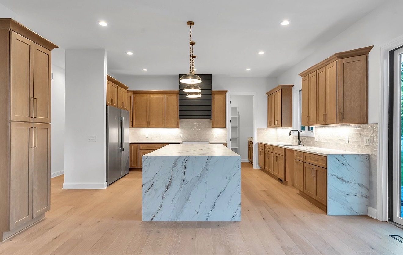 Maple kitchen open to living room with arched built-ins