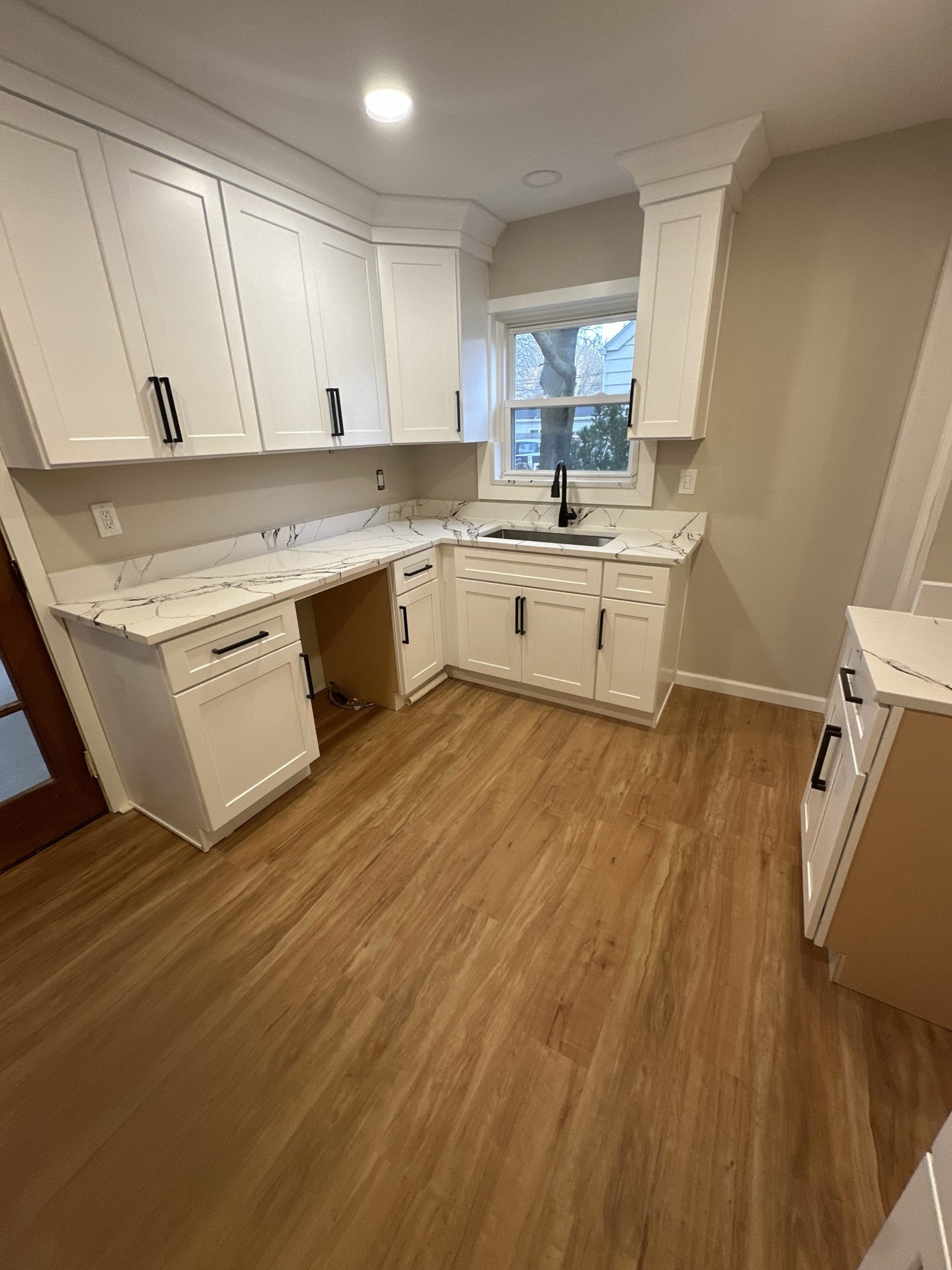 White shaker kitchen with black pulls and calacatta quartz counters