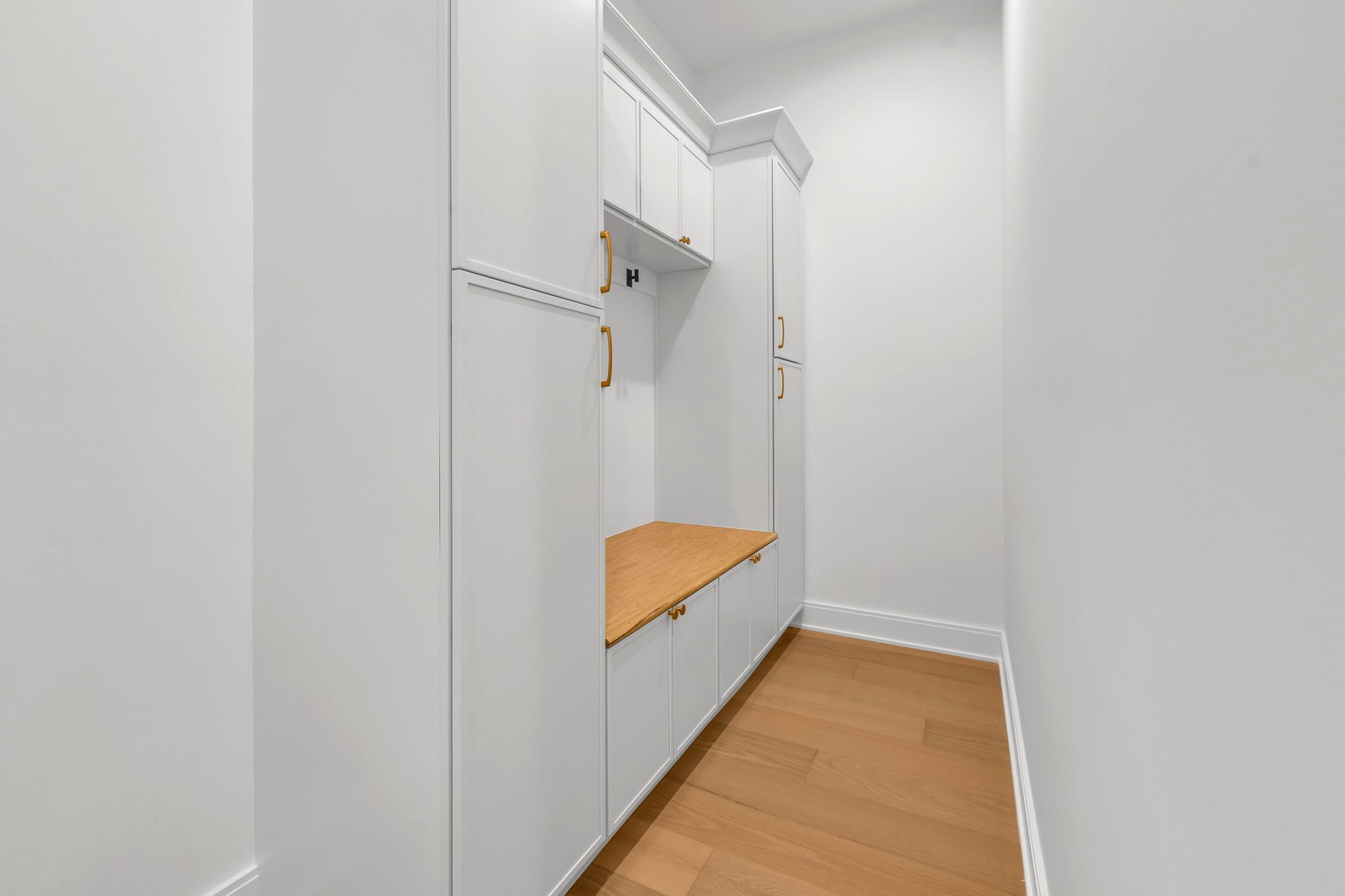 Mudroom with white lockers and oak bench